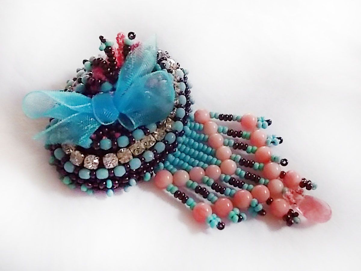 Naiad broche geborduurd met edelsteen kralen (Turkoois en Koraal), kristallen, koeienhuid en rocailles.