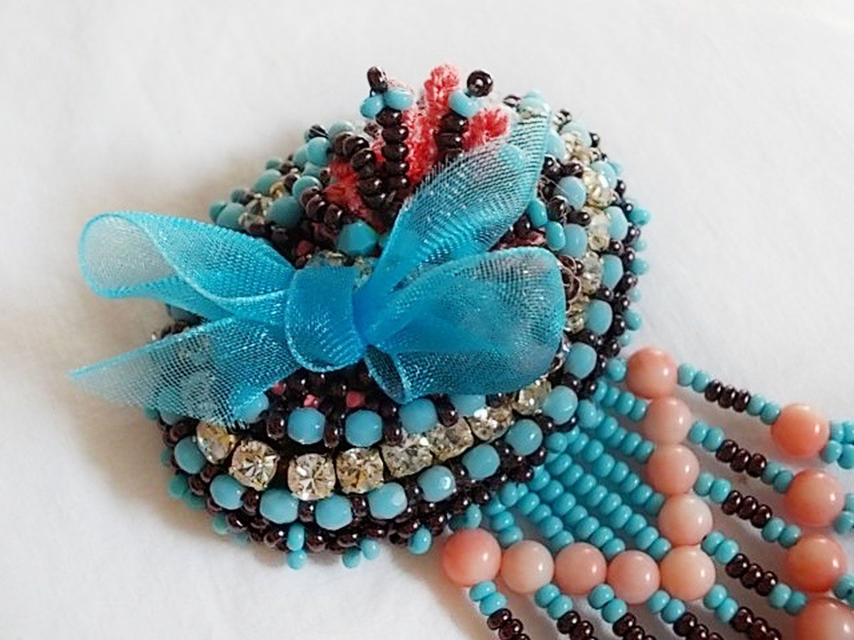 Naiad broche geborduurd met edelsteen kralen (Turkoois en Koraal), kristallen, koeienhuid en rocailles.