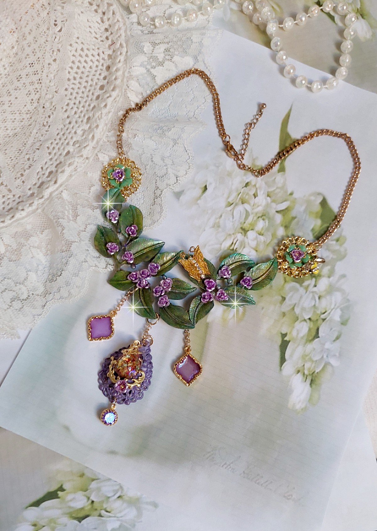 Collier Cam&eacute;lia Japonica mont&eacute; avec un motif feuilles aquarell&eacute;s &agrave; la main, paillettes, breloques papillons et abeille, roses m&eacute;tal, cabochon cristal, pendentifs &eacute;poxy aux couleurs d&rsquo;arc en ciel