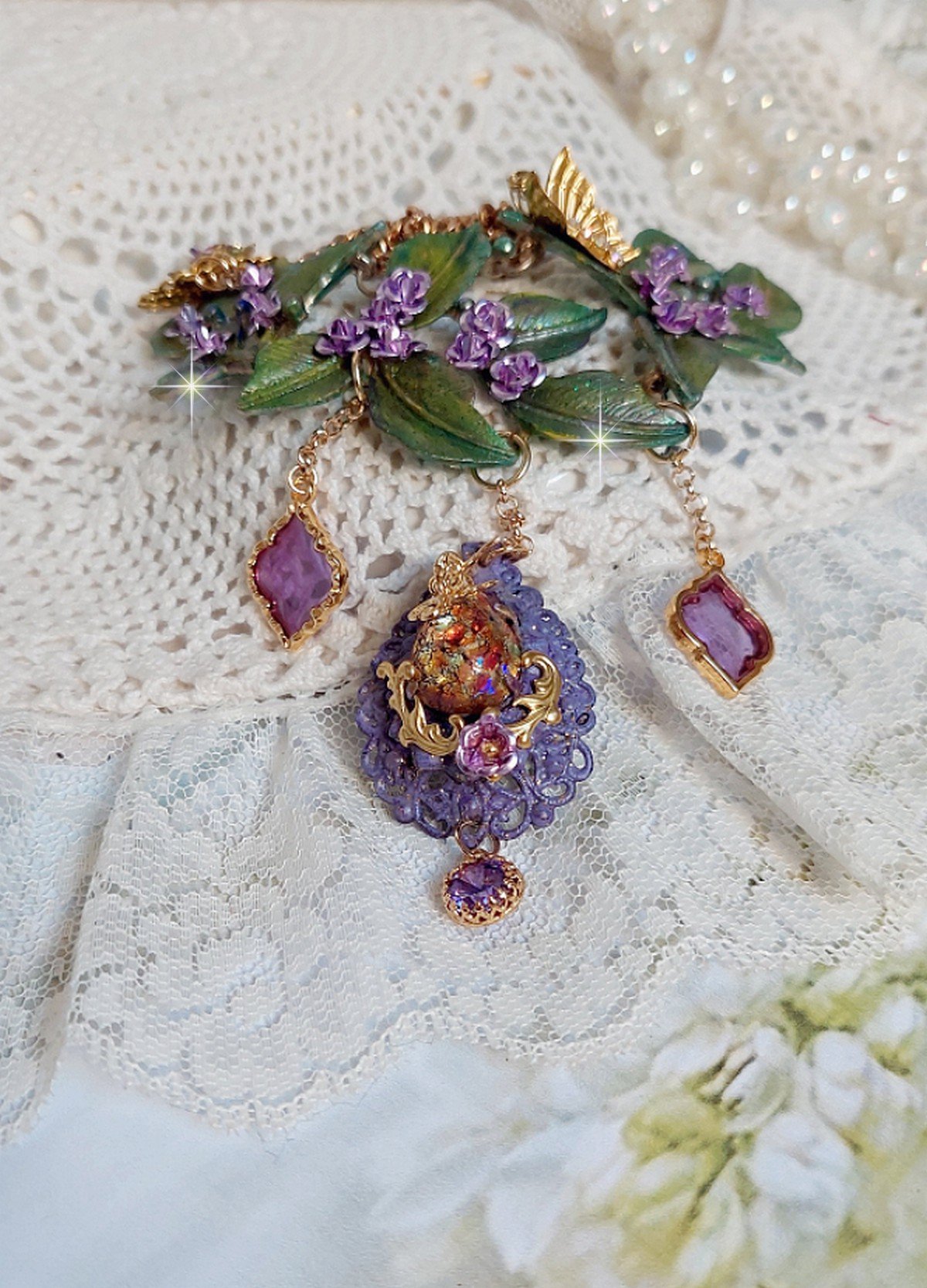 Collier Cam&eacute;lia Japonica mont&eacute; avec un motif feuilles aquarell&eacute;s &agrave; la main, paillettes, breloques papillons et abeille, roses m&eacute;tal, cabochon cristal, pendentifs &eacute;poxy aux couleurs d&rsquo;arc en ciel