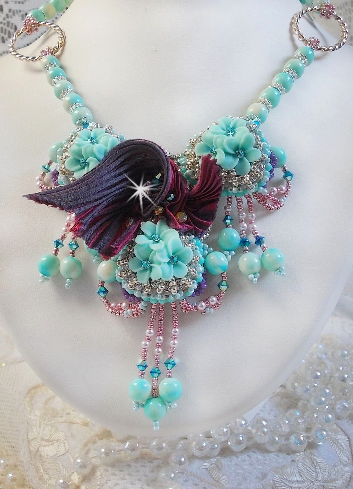 Blue Flowers Haute-Couture ketting geborduurd met Swarovski kristallen, een truffel/framboos zijden lint en rocailles.