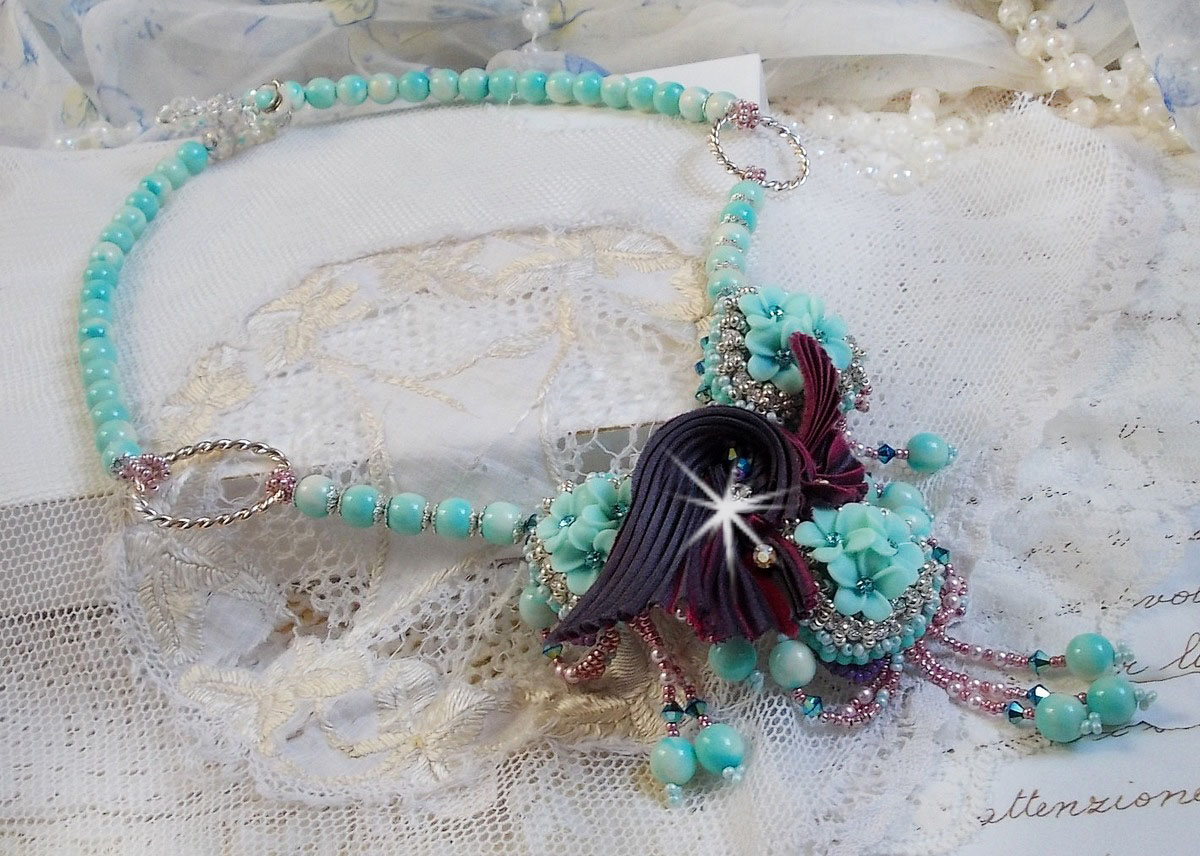 Blue Flowers Haute-Couture ketting geborduurd met Swarovski kristallen, een truffel/framboos zijden lint en rocailles.
