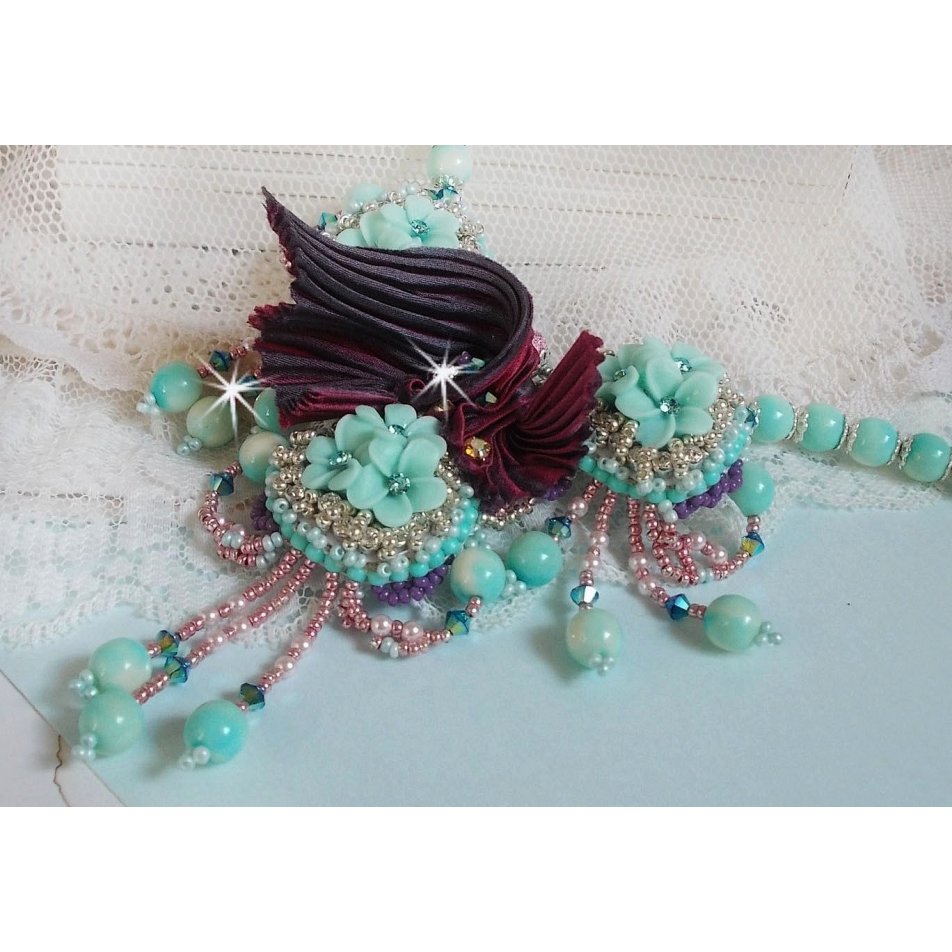 Blue Flowers Haute-Couture ketting geborduurd met Swarovski kristallen, een truffel/framboos zijden lint en rocailles.