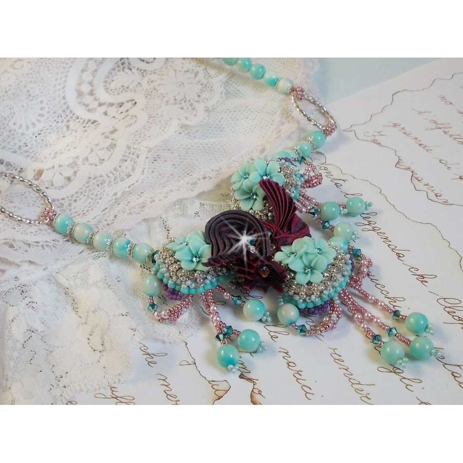 Blue Flowers Haute-Couture ketting geborduurd met Swarovski kristallen, een truffel/framboos zijden lint en rocailles.