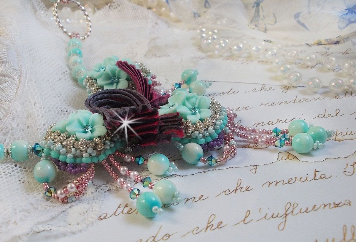 Blue Flowers Haute-Couture ketting geborduurd met Swarovski kristallen, een truffel/framboos zijden lint en rocailles.