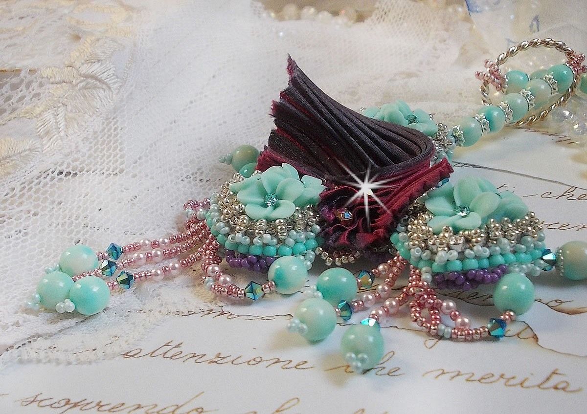 Blue Flowers Haute-Couture ketting geborduurd met Swarovski kristallen, een truffel/framboos zijden lint en rocailles.
