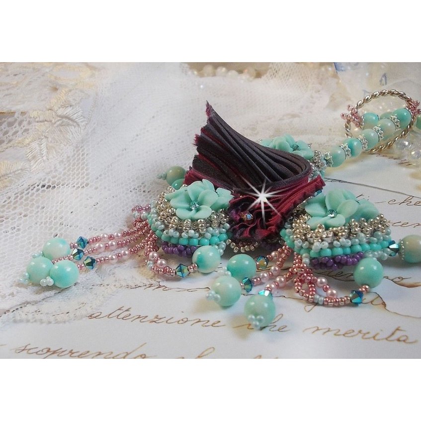 Blue Flowers Haute-Couture ketting geborduurd met Swarovski kristallen, een truffel/framboos zijden lint en rocailles.