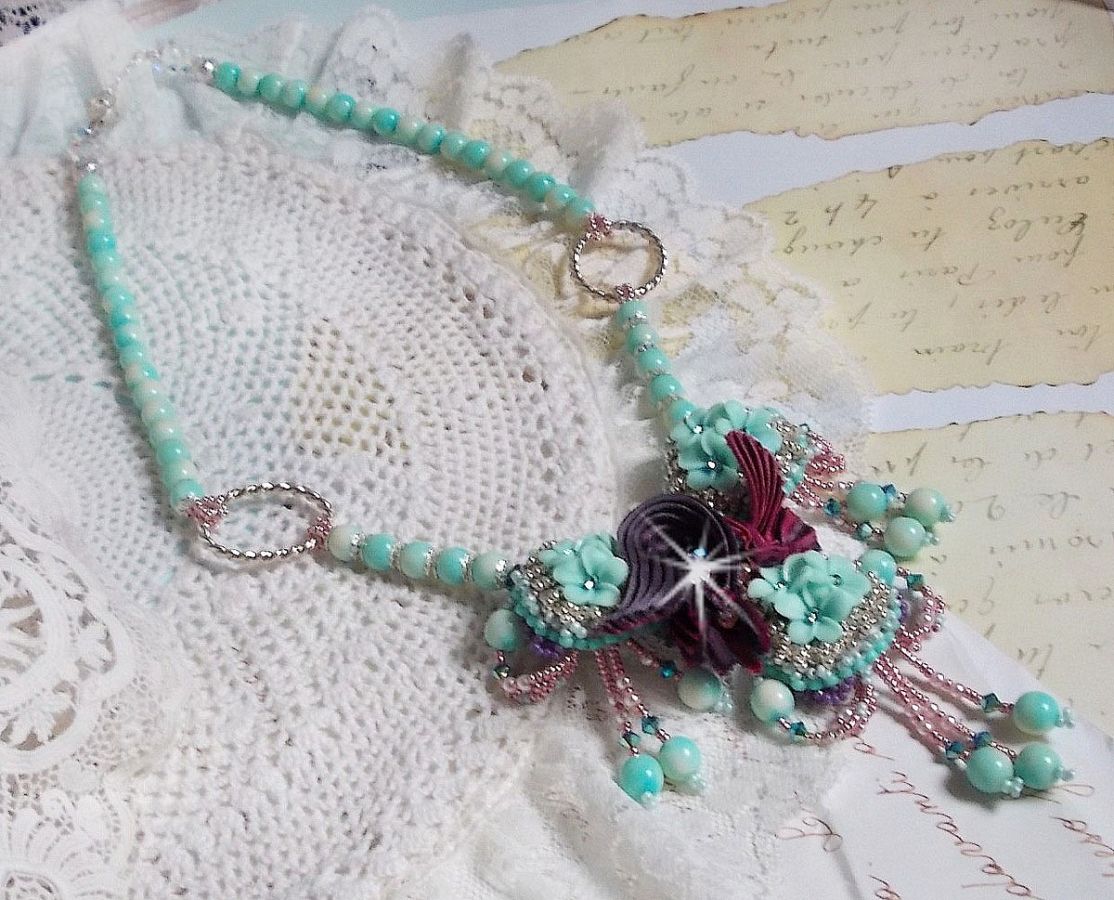 Blue Flowers Haute-Couture ketting geborduurd met Swarovski kristallen, een truffel/framboos zijden lint en rocailles.