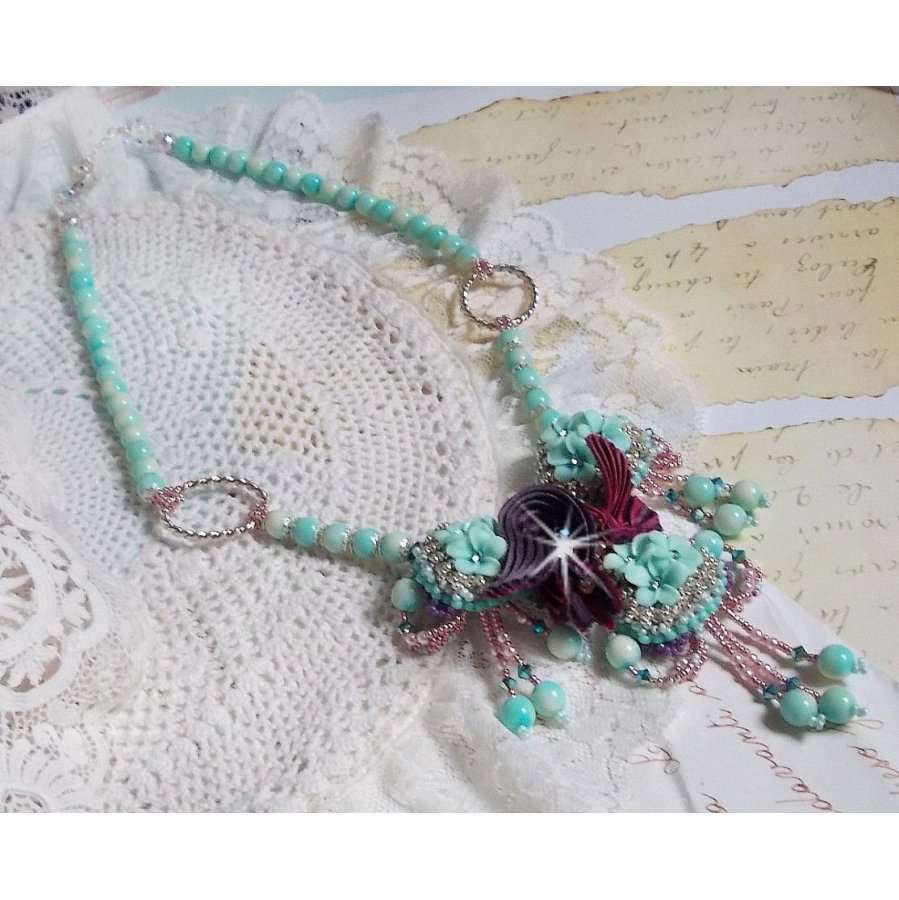 Blue Flowers Haute-Couture ketting geborduurd met Swarovski kristallen, een truffel/framboos zijden lint en rocailles.