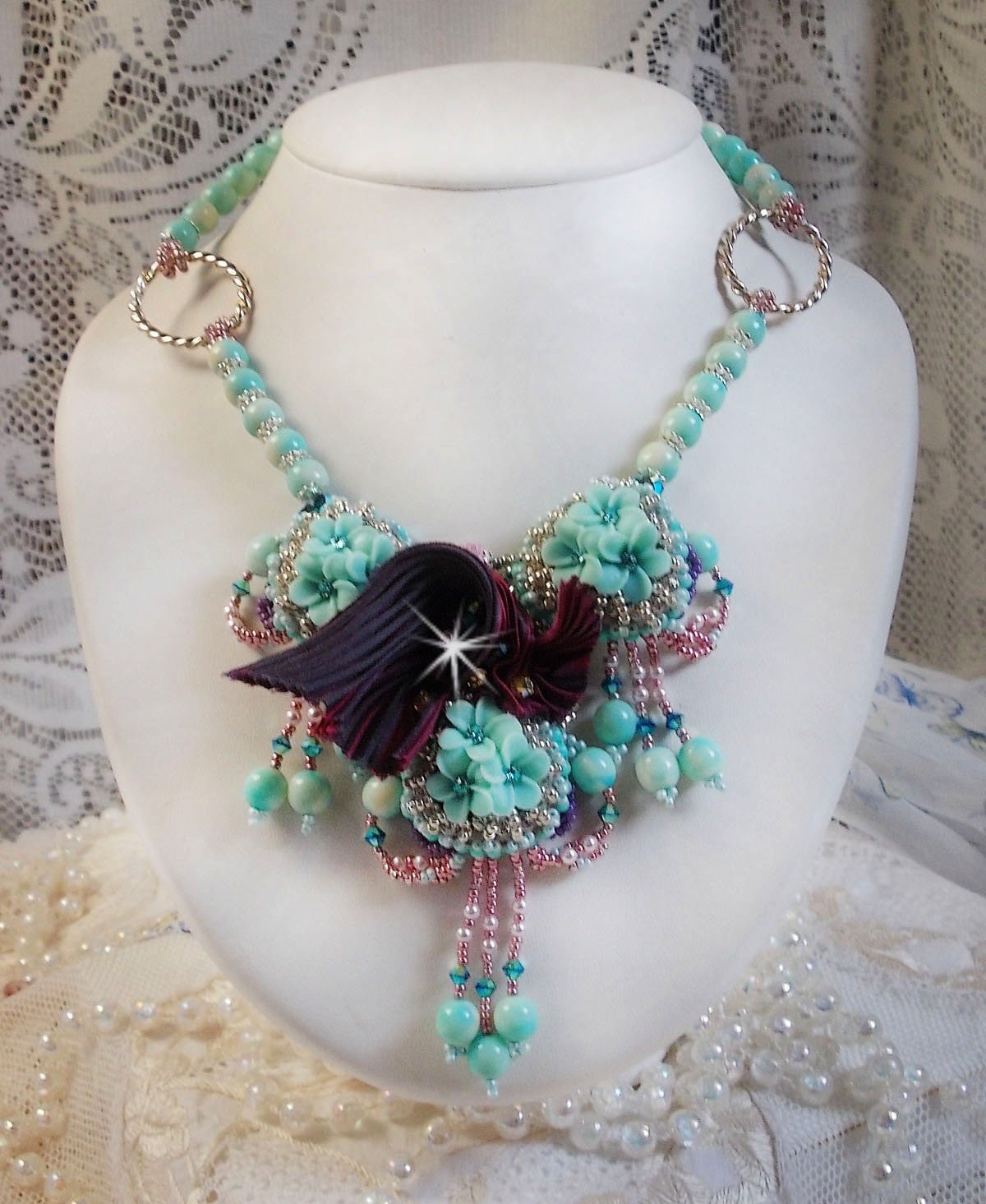 Blue Flowers Haute-Couture ketting geborduurd met Swarovski kristallen, een truffel/framboos zijden lint en rocailles.