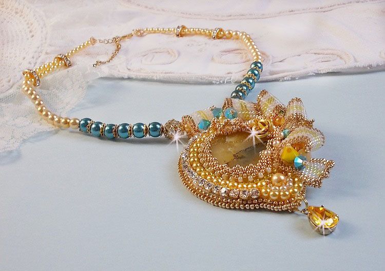 Haute-Couture Sunflower Gold hanger geborduurd met 24 karaats vergulde rocailles, een Madagaskar opaal en Swarovski kristallen.