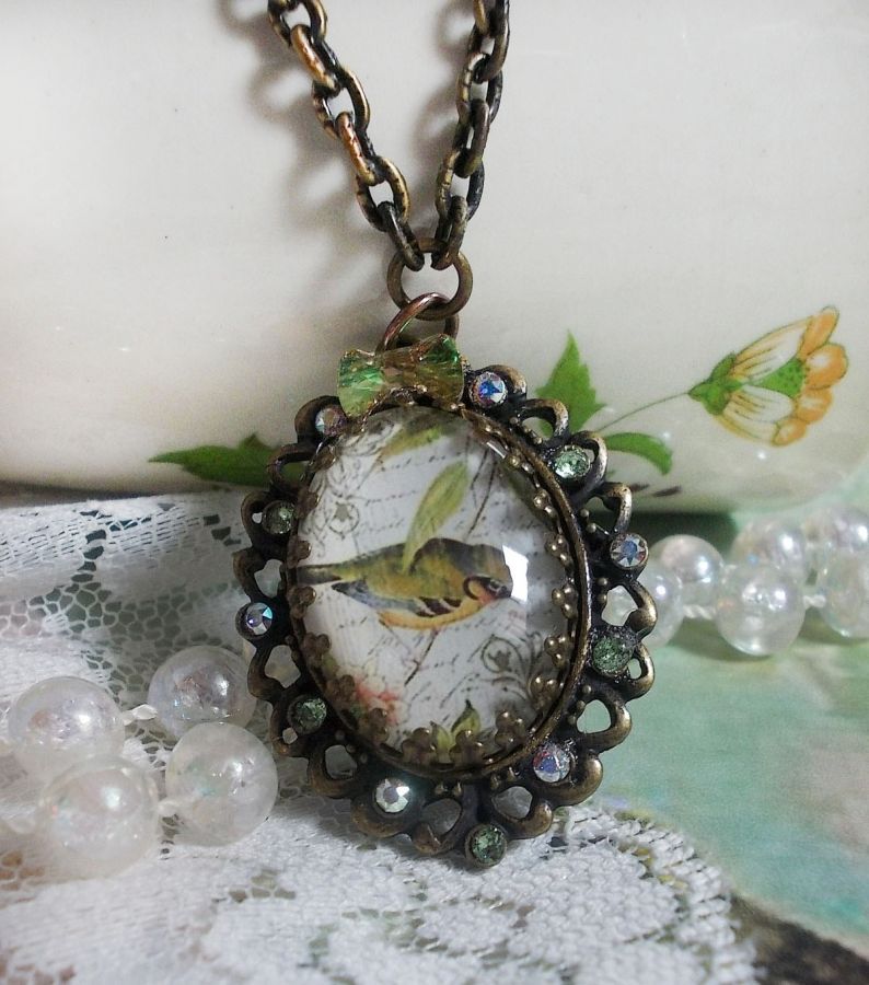 Tuinvogel ketting gemaakt met een braam cabochon en kristallen gemonteerd op bronzen accessoires