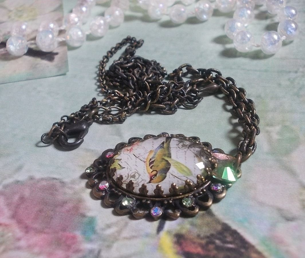 Tuinvogel ketting gemaakt met een braam cabochon en kristallen gemonteerd op bronzen accessoires