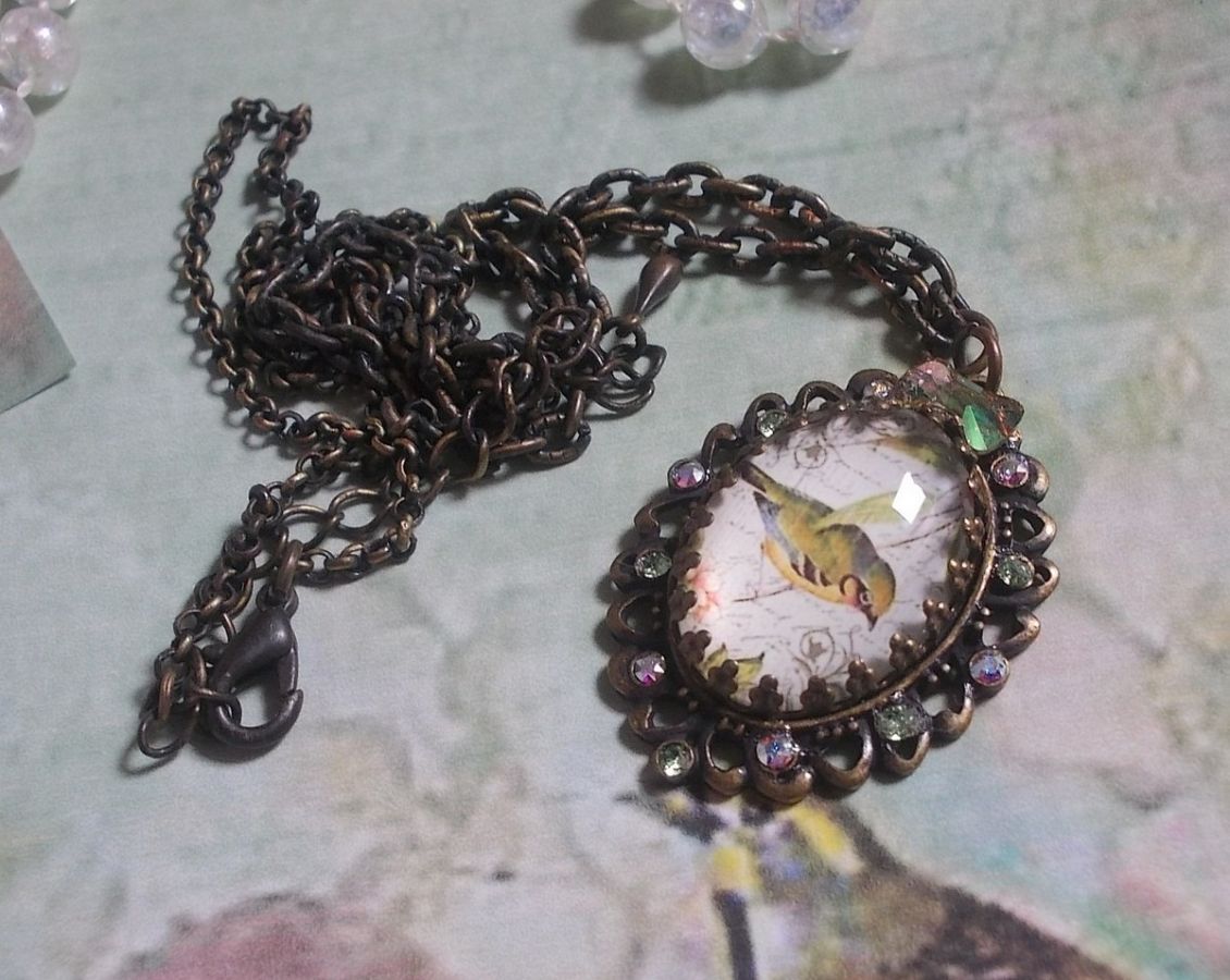 Tuinvogel ketting gemaakt met een braam cabochon en kristallen gemonteerd op bronzen accessoires