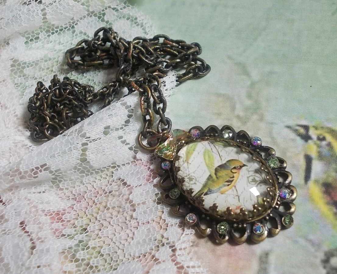Tuinvogel ketting gemaakt met een braam cabochon en kristallen gemonteerd op bronzen accessoires