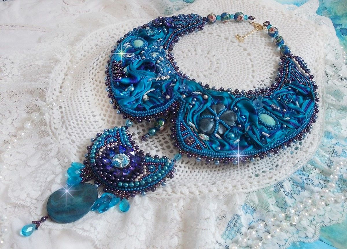 Royal Blue Haute-Couture slabbetjesketting geborduurd met een paars en eend blauw zijden lint, kristallen en diverse kralen. 