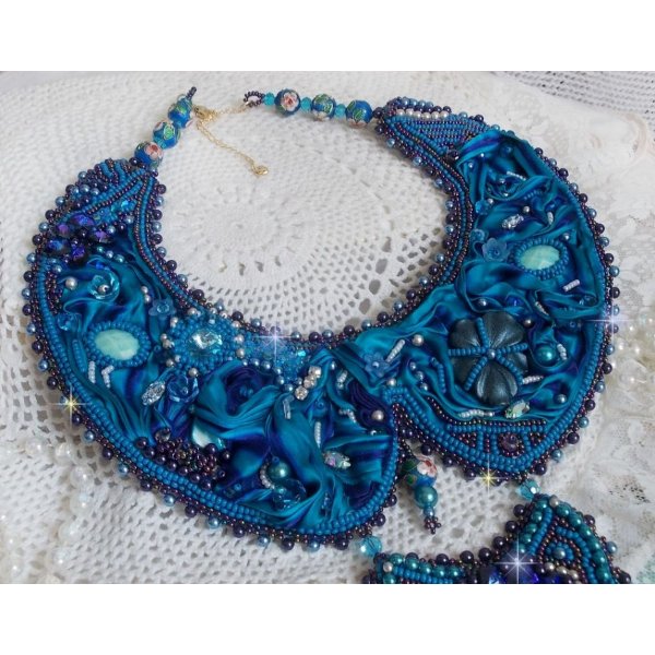 Royal Blue Haute-Couture slabbetjesketting geborduurd met een paars en eend blauw zijden lint, kristallen en diverse kralen. 