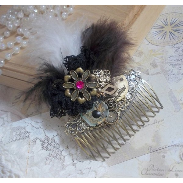 Curiosity Time haarkam gemaakt met zwart kant, diverse accessoires, gouden, zilveren en bronzen bedels met zwarte, bruine en witte veren.