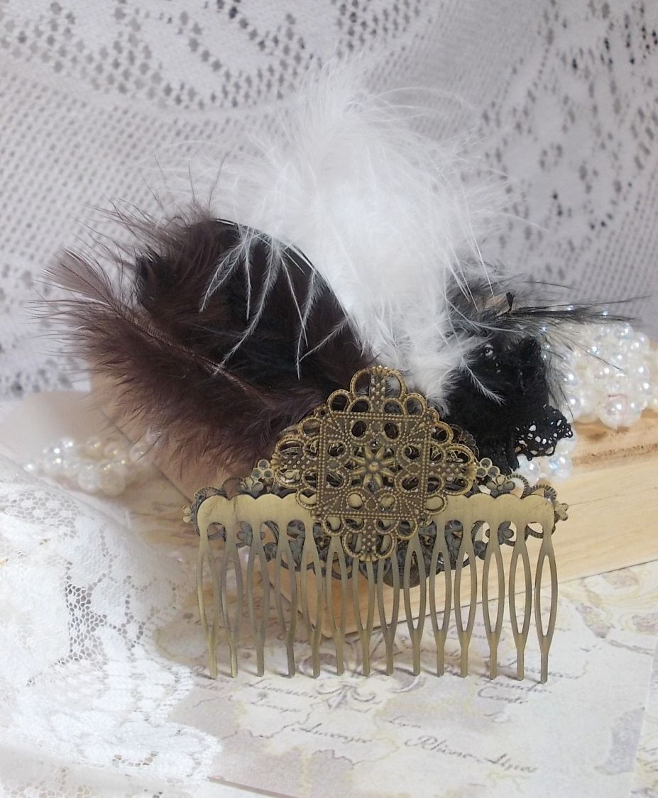 Curiosity Time haarkam gemaakt met zwart kant, diverse accessoires, gouden, zilveren en bronzen bedels met zwarte, bruine en witte veren.