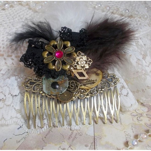 Curiosity Time haarkam gemaakt met zwart kant, diverse accessoires, gouden, zilveren en bronzen bedels met zwarte, bruine en witte veren.