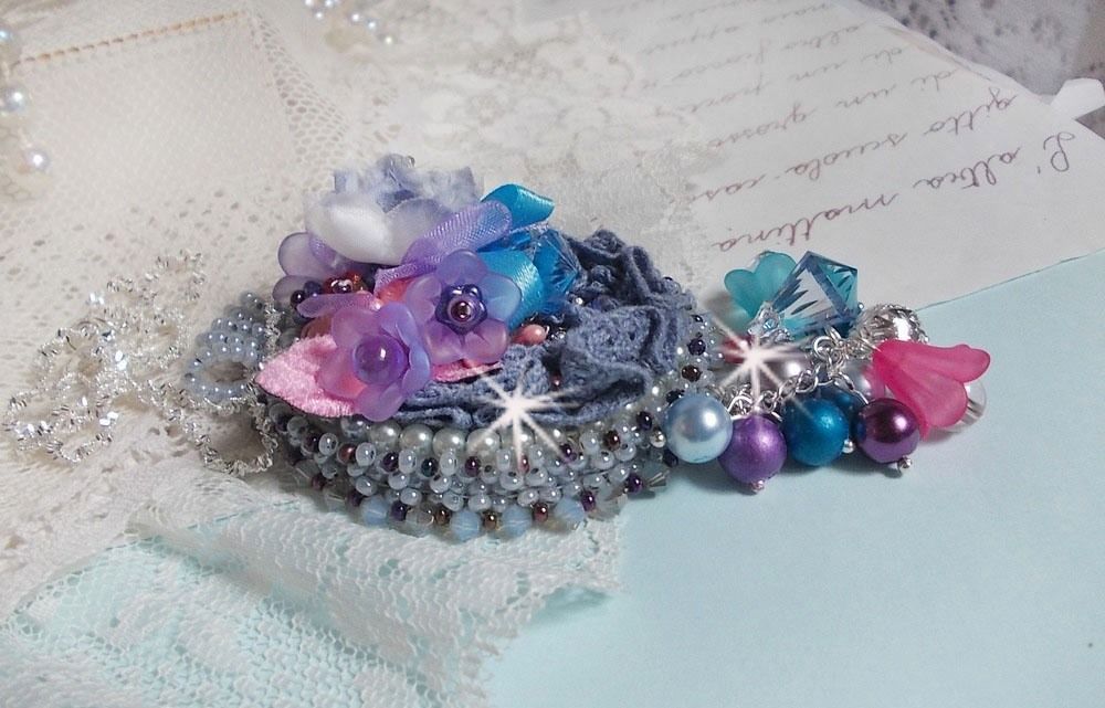 Mademoiselle Bluse Haute-Couture hanger geborduurd met Swarovski kristallen, resin bloemen, parels, rocailles en een 925 zilveren ketting.