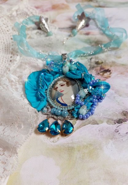 Pendentif Mademoiselle au style r&eacute;tro avec cabochon d&rsquo;une femme souriante, orn&eacute; d&rsquo;un ruban de soie Bleu, cristaux, perles verre : rocailles et roses, coupelles et cha&icirc;ne Argent 925/1000