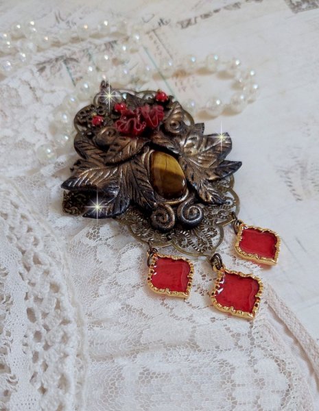 Pendentif M&eacute;lodie avec un cabochon &OElig;il de tigre orn&eacute; de perles en Jade Rouge vein&eacute; de Noir sur fleurs 5 p&eacute;tales et estampes mont&eacute;s sur une cha&icirc;ne bronze. Les pendants sont en r&eacute;sine &eacute;poxy Rouge