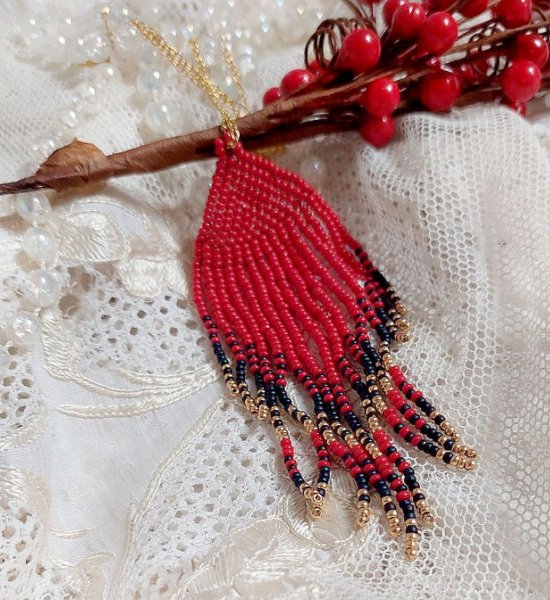 Rode Swirls Hanger gemaakt met kwaliteitszaadjes en een vergulde ketting.