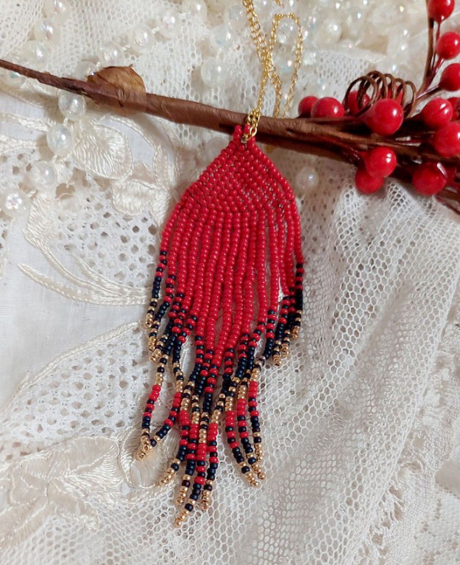 Rode Swirls Hanger gemaakt met kwaliteitszaadjes en een vergulde ketting.