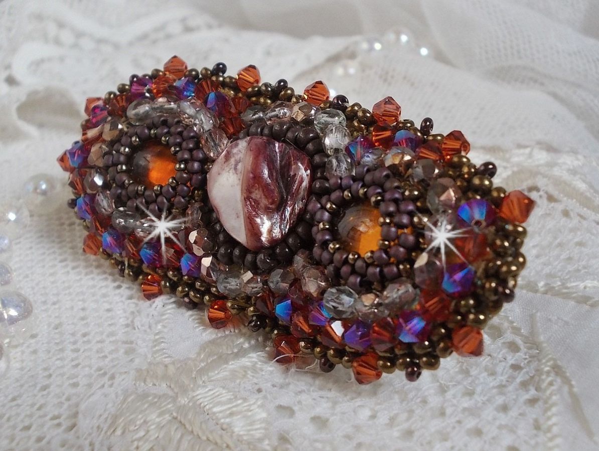 Topaas haarspeld geborduurd met een mahonie parelmoer cabochon, Swarovski kristallen en rocailles.