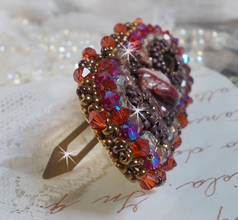 Topaas haarspeld geborduurd met een mahonie parelmoer cabochon, Swarovski kristallen en rocailles.