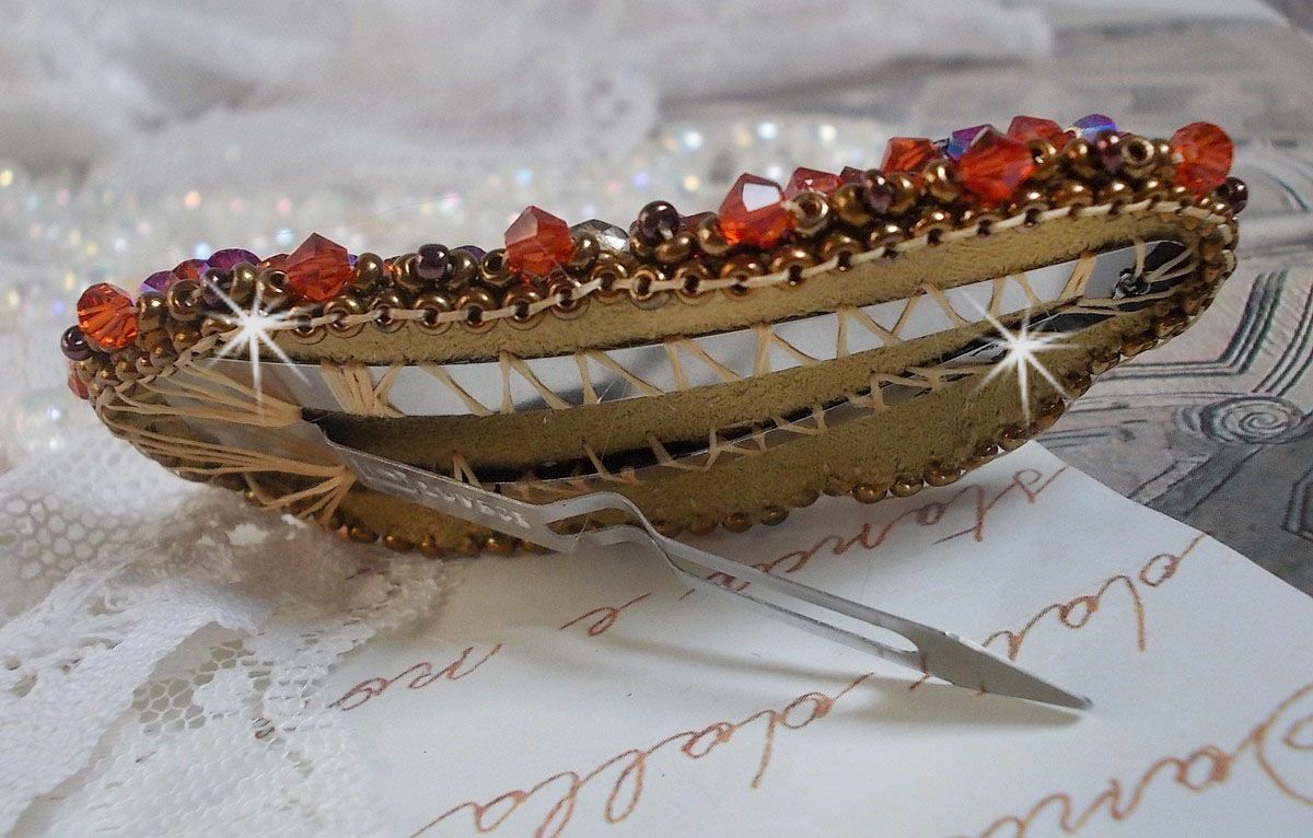 Topaas haarspeld geborduurd met een mahonie parelmoer cabochon, Swarovski kristallen en rocailles.