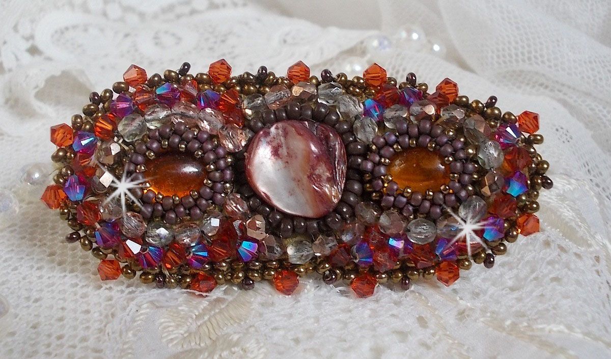 Topaas haarspeld geborduurd met een mahonie parelmoer cabochon, Swarovski kristallen en rocailles.