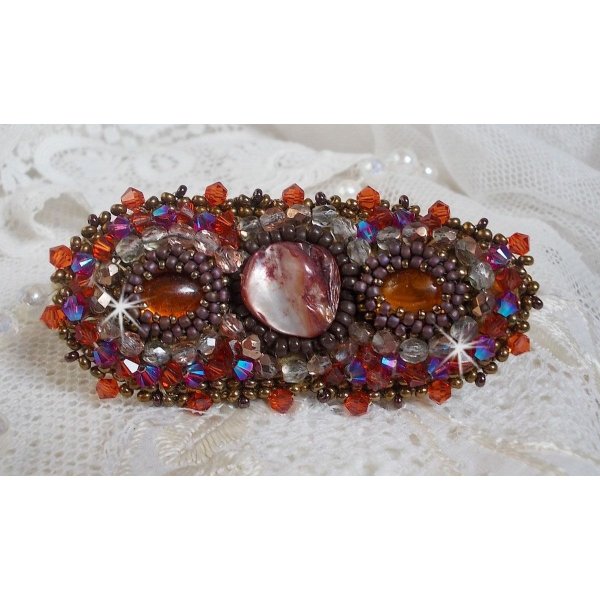 Topaas haarspeld geborduurd met een mahonie parelmoer cabochon, Swarovski kristallen en rocailles.