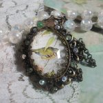 Tuinvogel ketting gemaakt met een braam cabochon en kristallen gemonteerd op bronzen accessoires