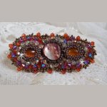 Topaas haarspeld geborduurd met een mahonie parelmoer cabochon, Swarovski kristallen en rocailles.