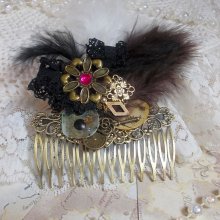 Curiosity Time haarkam gemaakt met zwart kant, diverse accessoires, gouden, zilveren en bronzen bedels met zwarte, bruine en witte veren.