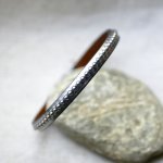 Damesarmband in donkergrijs metallic leer met zilveren kralen 