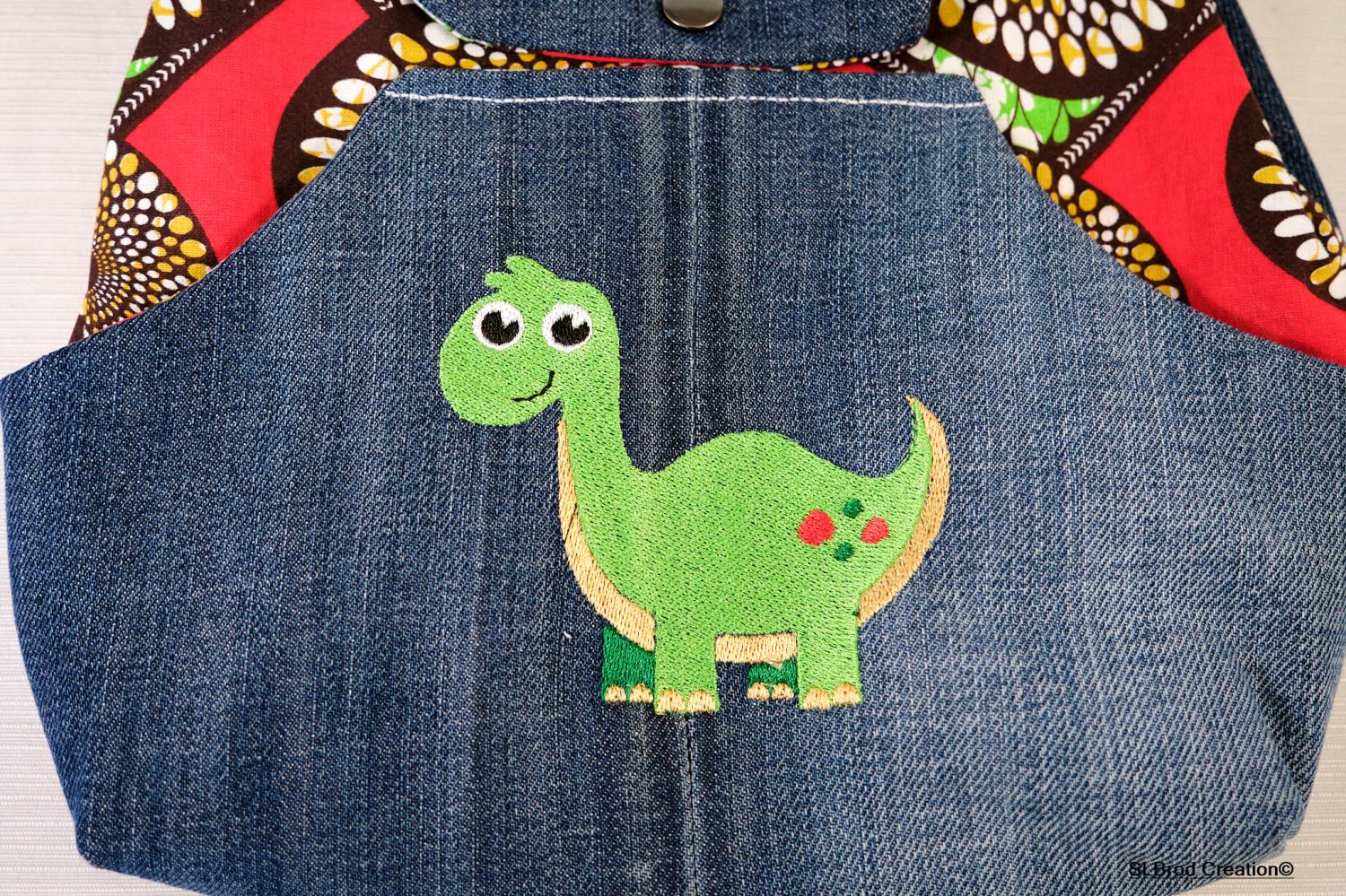 Kinderrugzak geborduurd met dinosaurus en was te personaliseren met uw naam