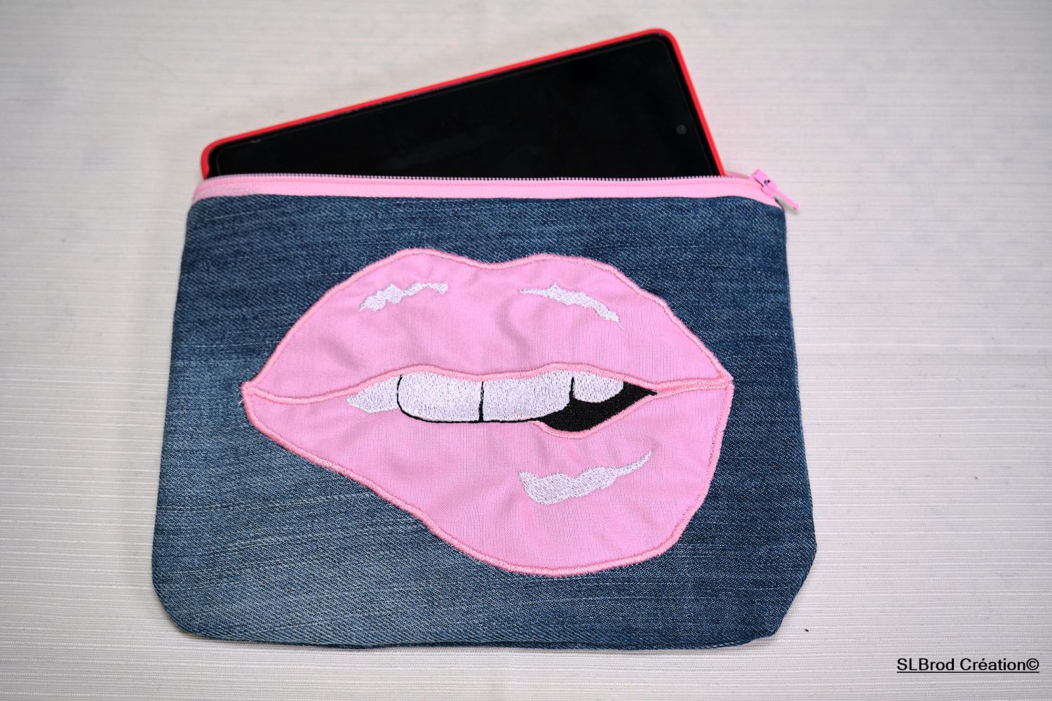 Platte koffer geborduurd met roze mond