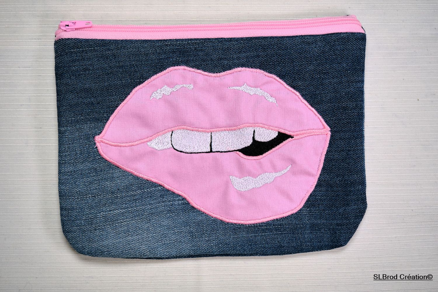 Platte koffer geborduurd met roze mond